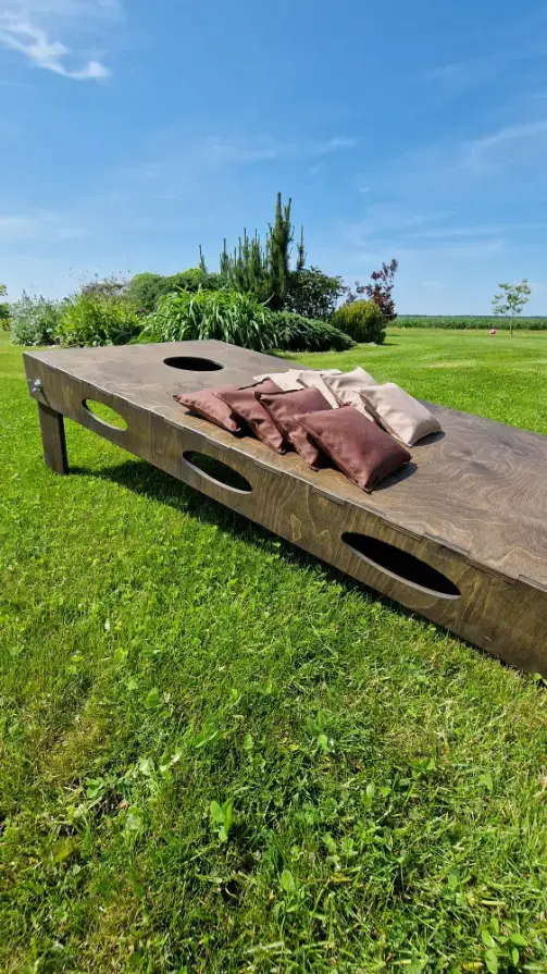 populiarus komandinis lauko žaidimas, puikiai tinkantis teambuildingams, gimtadieniams, įmonių šventėms ir aktyviam laisvalaikiui. Meskite kukurūzų maišelius į taikinį, rinkite taškus ir siekite pergalės iki 21 taško! Galimi individualūs užsakymai. Užsisakykite kokybiškus lauko žaidimus tiesiai iš gamintojo medzio karma