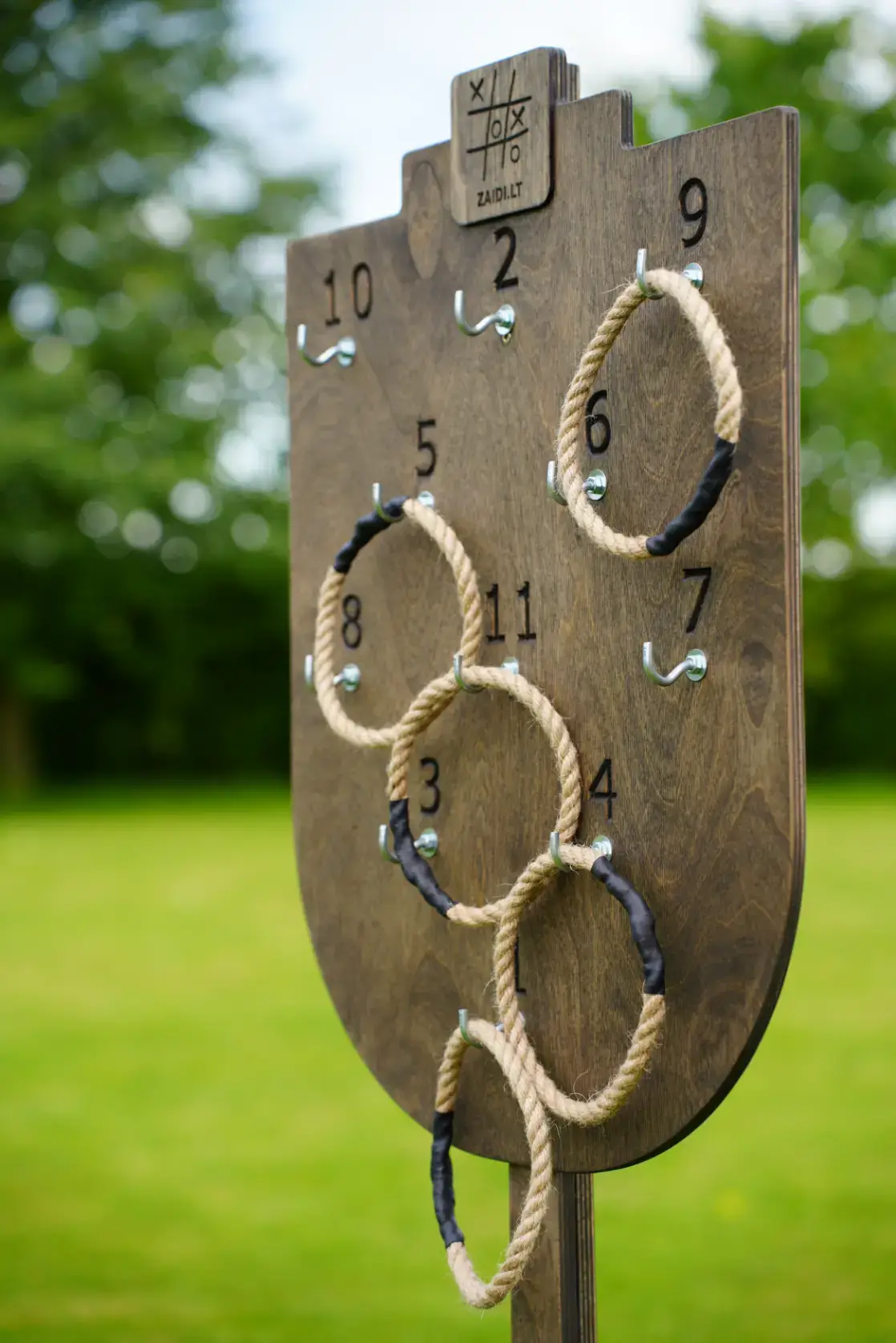 Medinis taiklumo žaidimas „Žiedų karalius“ – virviniai žiedai metami į vertikaliai stovinčią taikinio lentą.