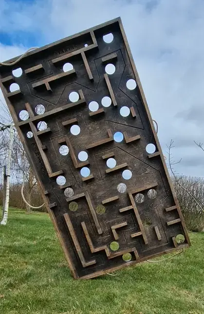 Medistau (Medžio Karma) gamintas medinis horizontalus lauko labirinto žaidimas vaikams ir suaugusiems – didelė iššūkių lenta su skylėmis ir takeliais.