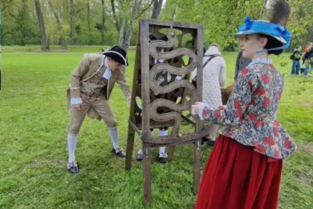 Moterys žaidžia medinį lauko žaidimą Gyvatėlę vasarą – koordinacijos žaidimas lauke suaugusiems. lauko žaidimų gamyba medžio karma