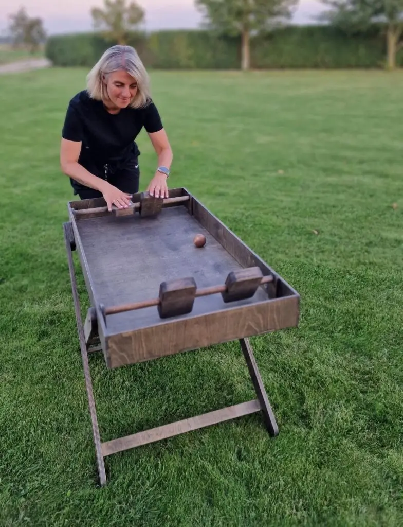 Medžio Karma stalo futbolas – sulankstomų kojų konstrukcija iš šono, tinka prie įmonės stendo